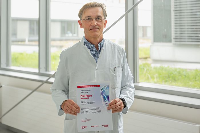 Das Bild zeigt Prof. Dr. Peter Reimer mit der Auszeichnung